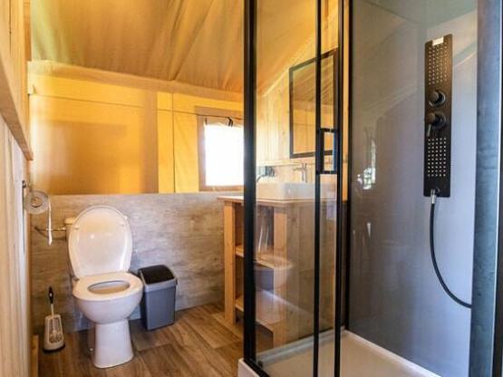 Tente safari de luxe Woody 25 pour 4 personnes incluant des installations sanitaires et une cuisine.